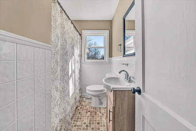 a view of an empty room with window and bathroom