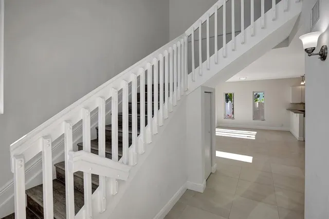a view of staircase with lots of frames and white walls