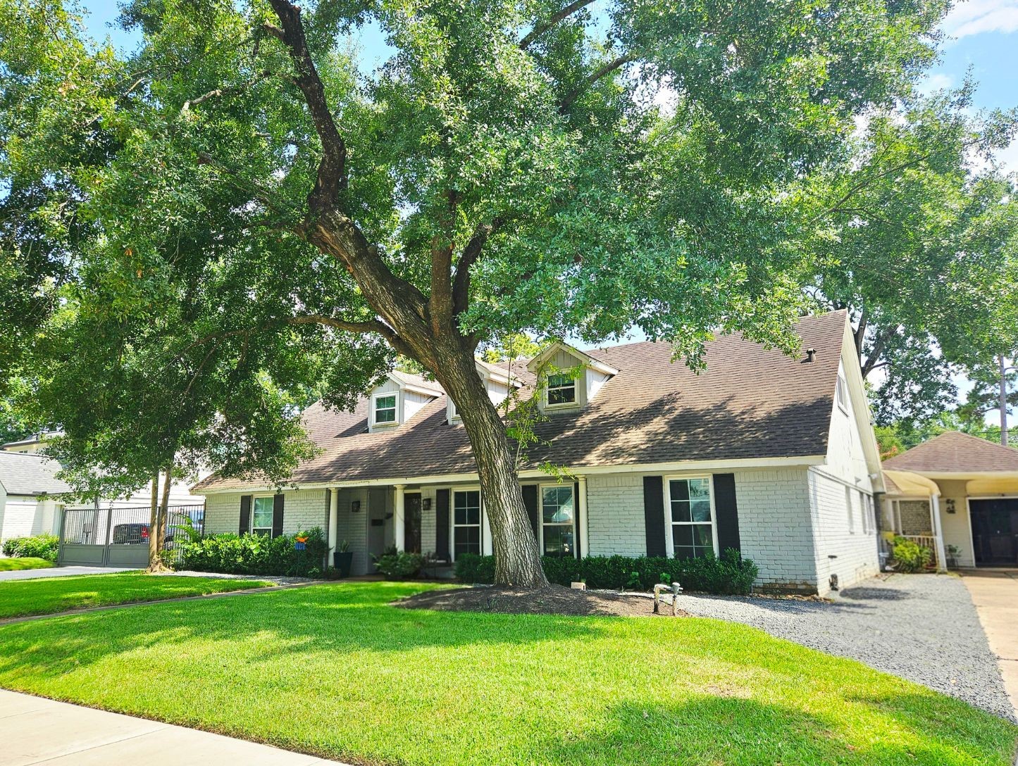 13047 Taylorcrest Road Houston, TX 77079 - Photo 3 of 23 A side perspective highlights the expansive front yard, towering mature tree, & inviting approach to this beautifully maintained home, complete with a detached 2-car garage.