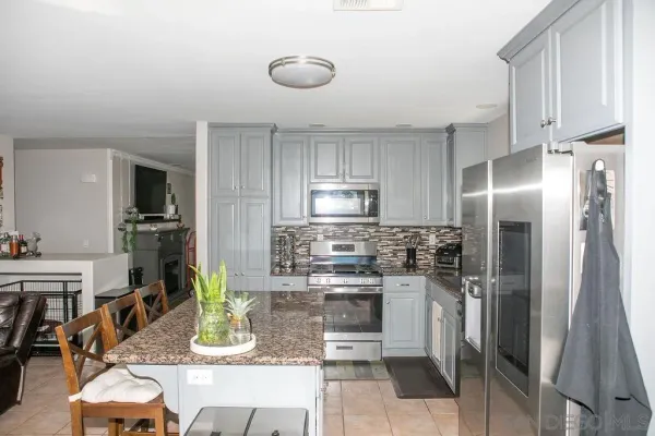 a kitchen with stainless steel appliances granite countertop a refrigerator and a stove top oven