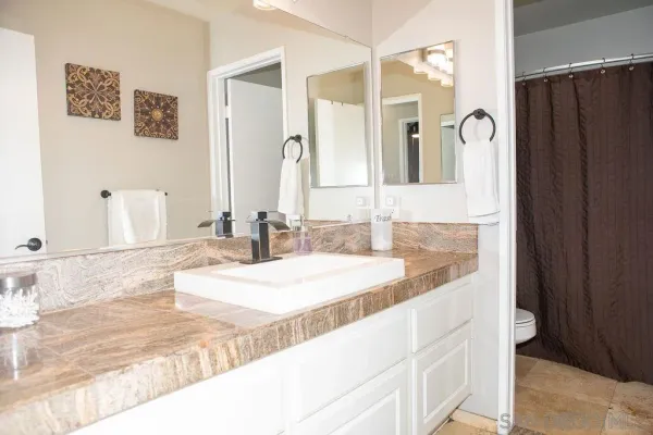 a bathroom with a granite countertop sink and a mirror