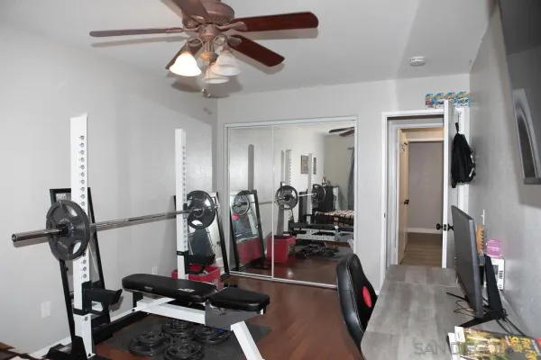 a view of a patio with table and chairs under an umbrella with a small yard