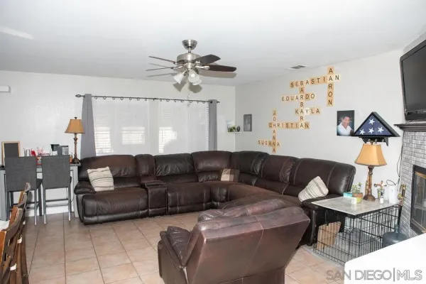 a living room with furniture a ceiling fan and a rug