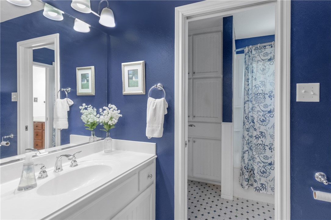 9997 Calhoun Road Bryan, TX 77808 - Photo 13 of 50 a bathroom with a sink a vanity and a mirror