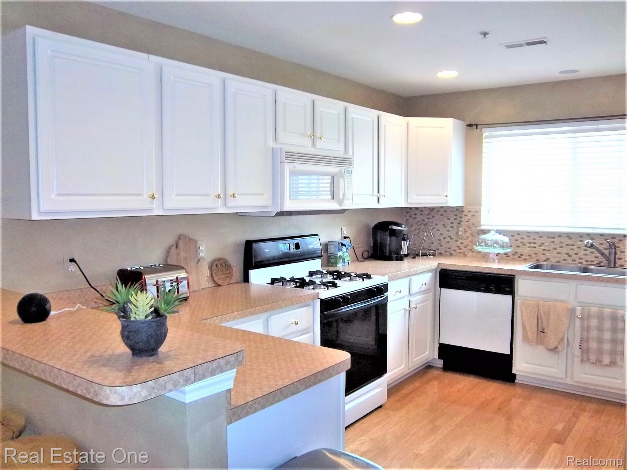 16802 Farmington Road Livonia, MI 48154 - Photo 6 of 23 KITCHEN WITH GAS STOVE AND MICROWAVE