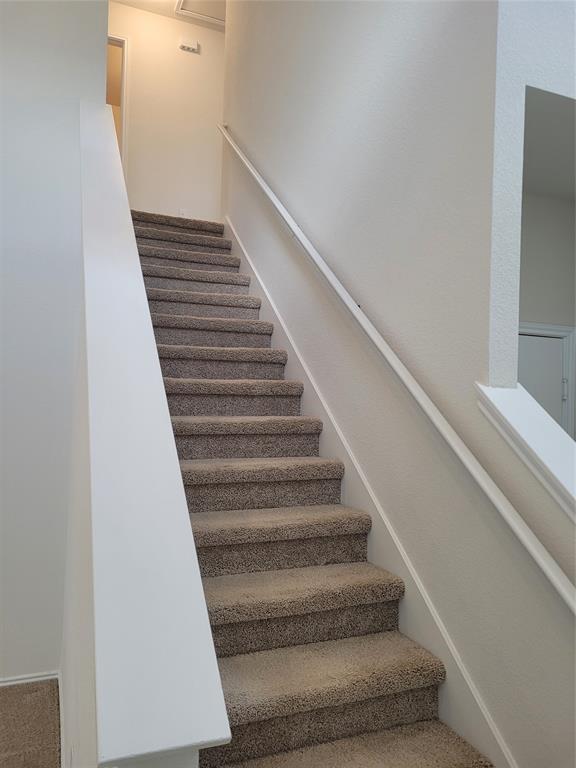 14917 Gypsum Mill Road Manor, TX 78653 - Photo 12 of 28 A well-lit stairway with soft carpeting leads to the upper level of the home.