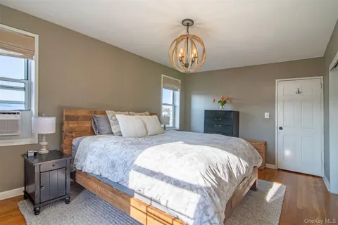 a bedroom with bed and wooden floor