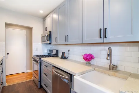 a kitchen with granite countertop a sink cabinets and wooden floor