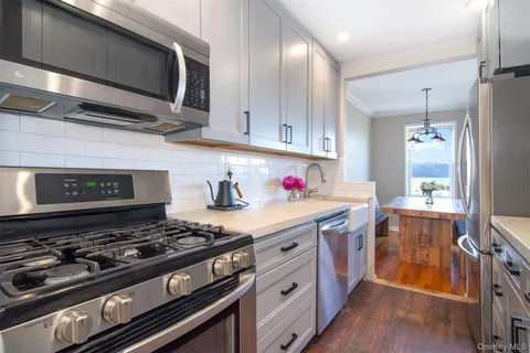 a kitchen with stainless steel appliances granite countertop a stove and a wooden cabinets