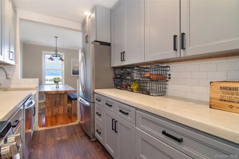 a kitchen with stainless steel appliances cabinets wooden floor and a sink