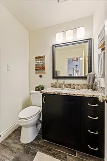 a bathroom with a granite countertop toilet sink and a mirror