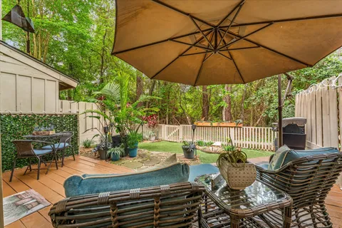 a view of a backyard with table and chairs potted plants and a wooden fence
