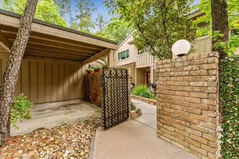 a front view of a house with a garden and trees