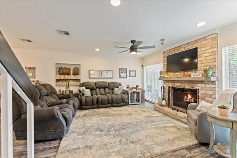 a living room with furniture a fireplace and a flat screen tv