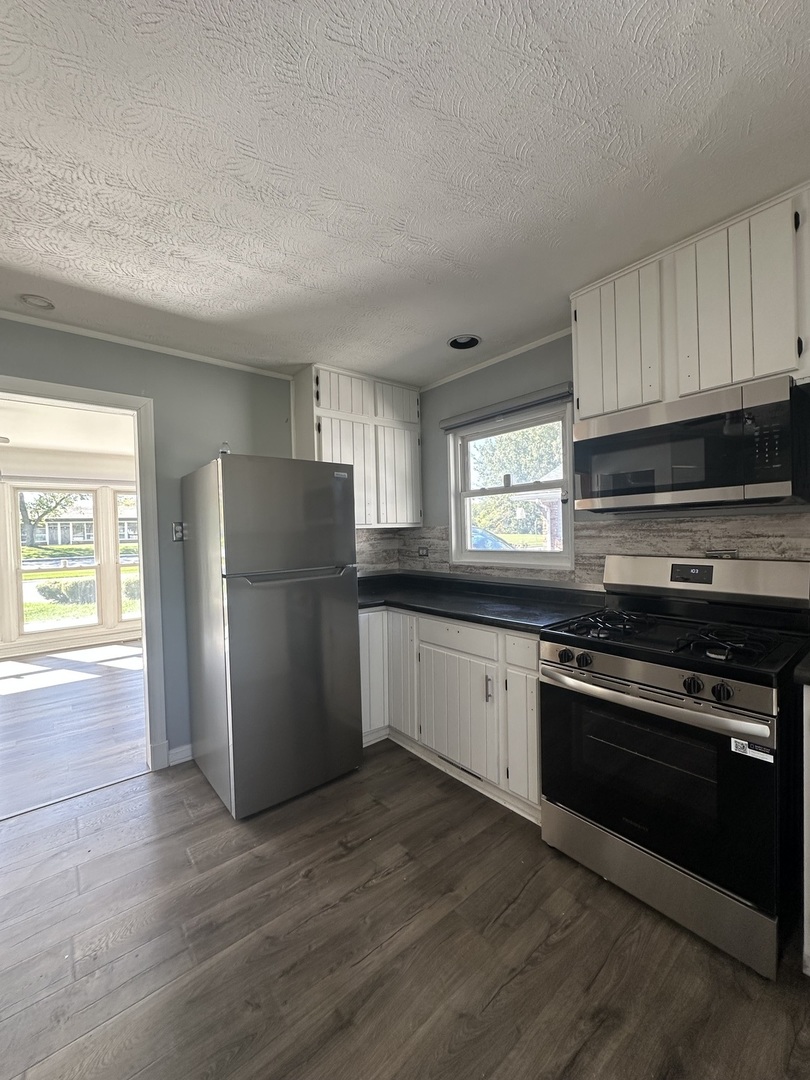 306 Mohawk Street Park Forest, IL 60466 - Photo 4 of 12 a kitchen with a refrigerator stove and wooden cabinets