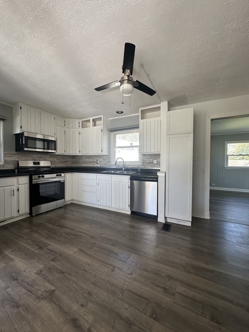 306 Mohawk Street Park Forest, IL 60466 - Photo 5 of 12 a kitchen with stainless steel appliances granite countertop a stove top oven a sink and a refrigerator