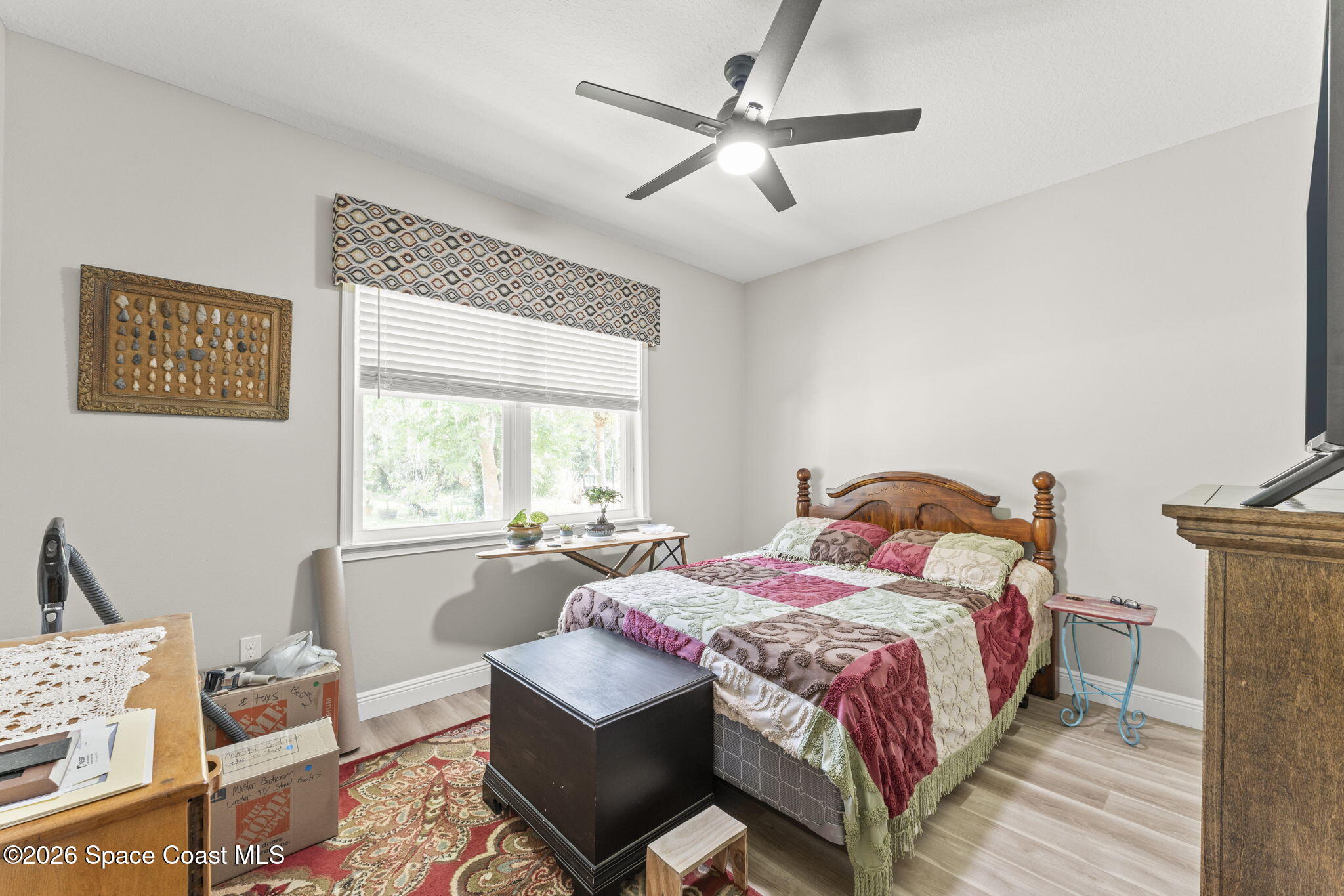 1740 Ford Road Mims, FL 32754 - Photo 27 of 43 a bedroom with a bed a chandelier and a window