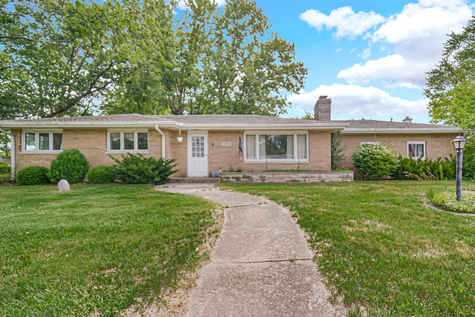 a front view of a house with a yard and potted plants