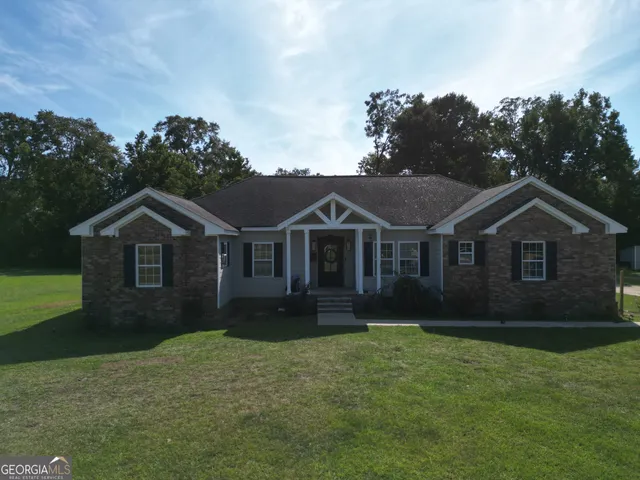 a front view of a house with a yard and trees