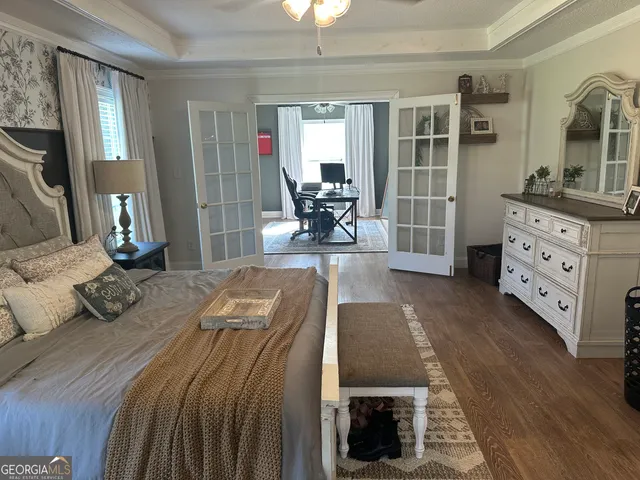 a bed room with a bed couches and a flat tv screen