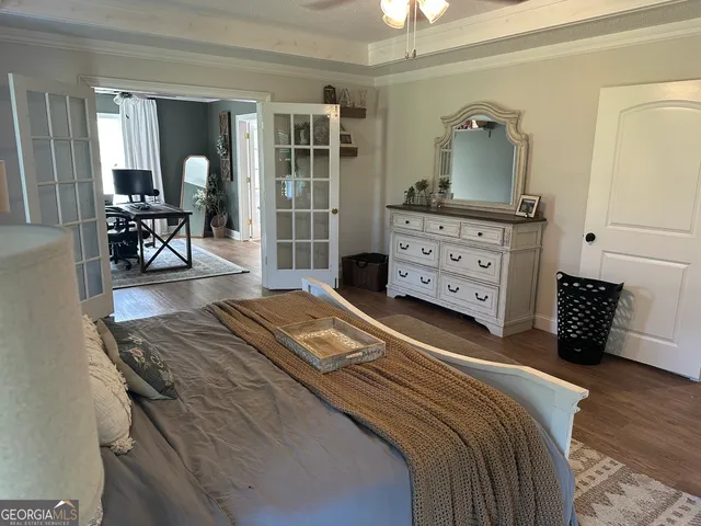a bedroom with a bed and wooden floor
