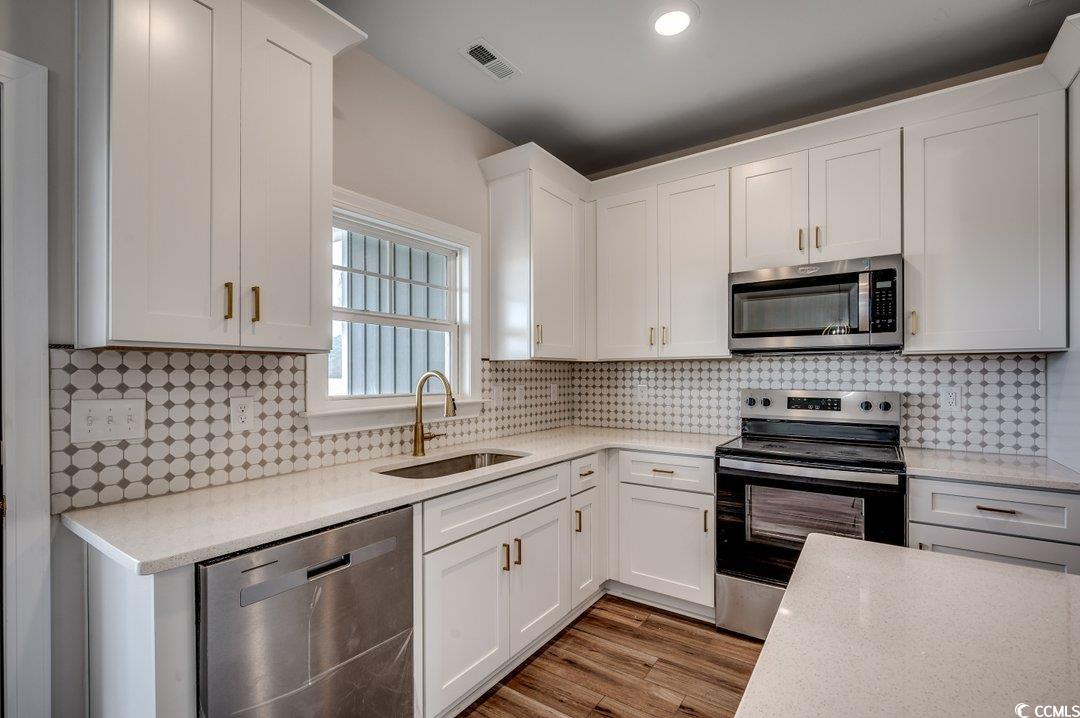 4975 Dupont Road Aynor, SC 29511 - Photo 8 of 22 Kitchen featuring sink, white cabinets, and applia