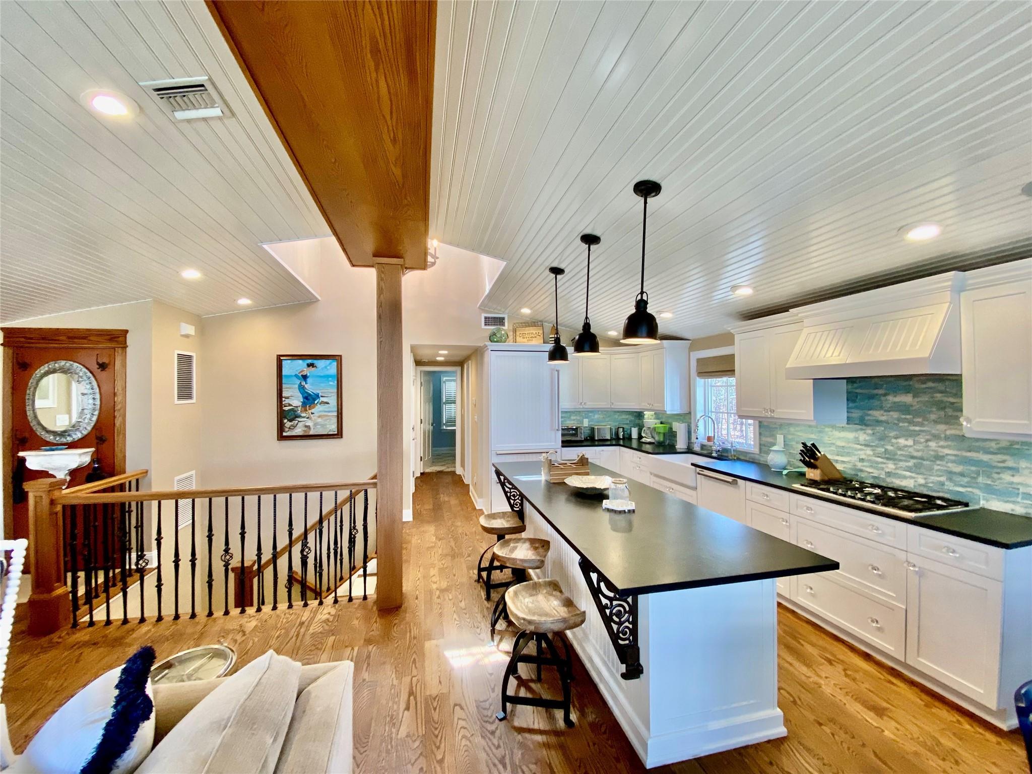 780 Minnehaha Boulevard Southold, NY 11971 - Photo 6 of 23 Kitchen with custom range hood, stone countertops, stainless steel gas stovetop, and lofted ceiling