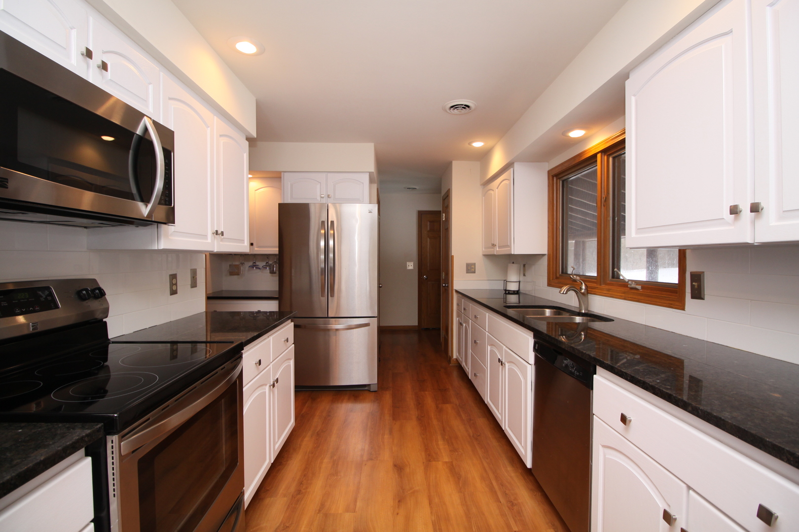 2002 Hawthorn Road Marengo, IL 60152 - Photo 6 of 27 a kitchen with stainless steel appliances a sink dishwasher a stove top oven a refrigerator cabinets and wooden floor