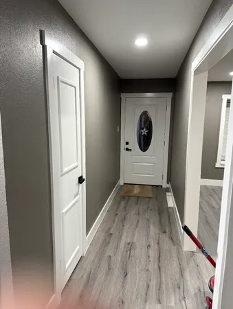 a view of a hallway with wooden floor and staircase