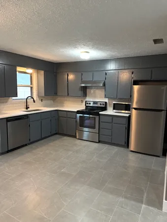 a large kitchen with cabinets and stainless steel appliances