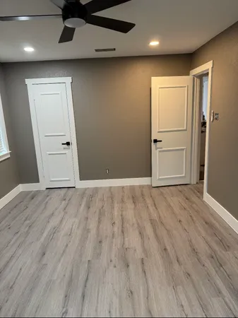 a view of an empty room with wooden floor