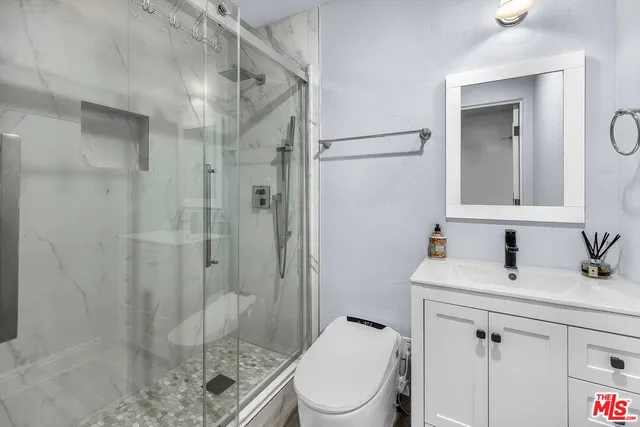 a bathroom with a sink a toilet and shower