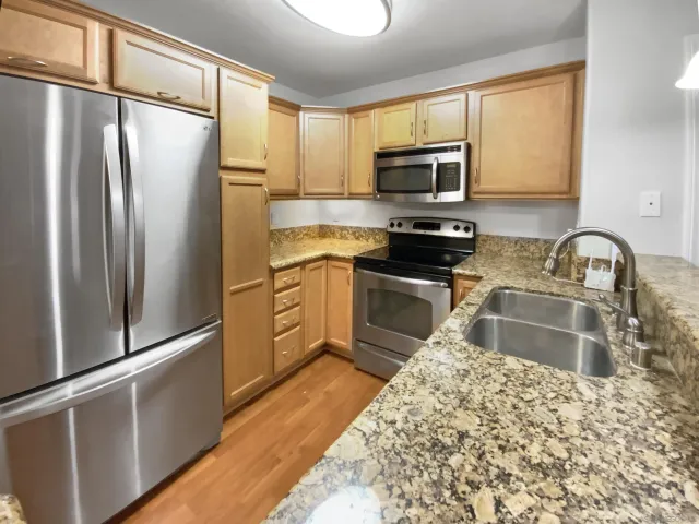 a kitchen with stainless steel appliances granite countertop a refrigerator sink and microwave
