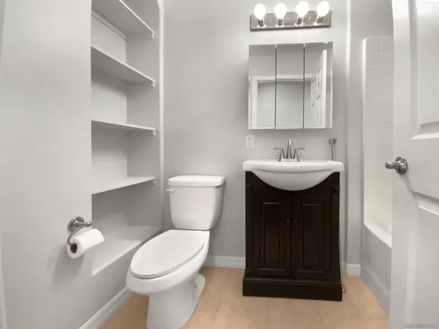 a bathroom with a sink toilet and mirror