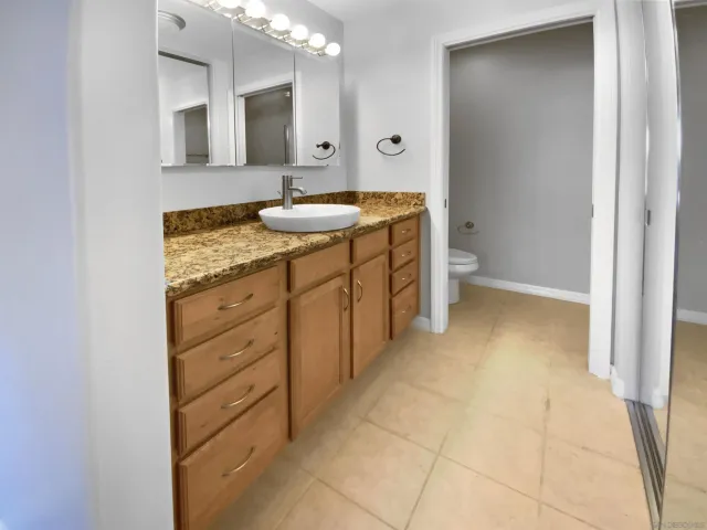 a bathroom with a granite countertop sink and a mirror