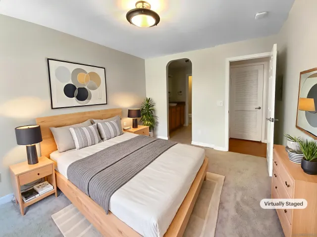 a bedroom with a bed and a painting on the wall