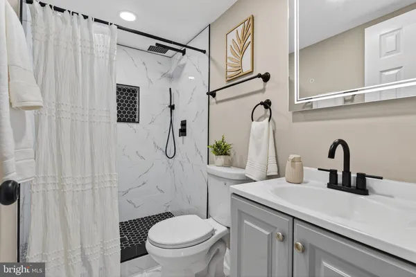 a bathroom with a sink a toilet and shower curtain