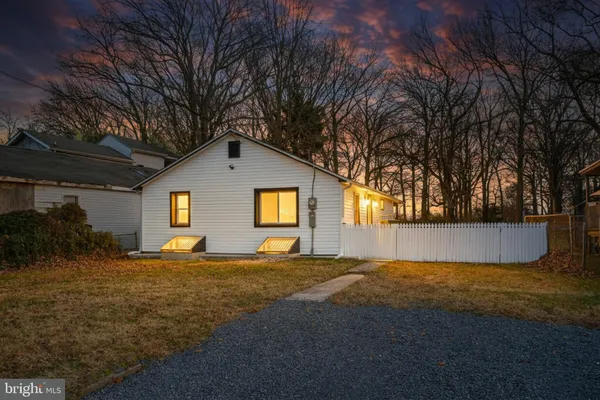 a front view of house with yard and trees in the background