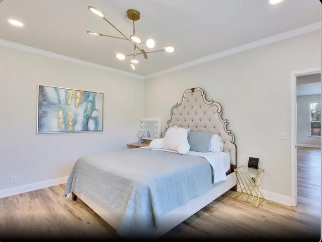a bedroom with a large bed and a chandelier