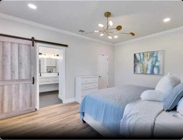 a bedroom with a large bed and a chandelier