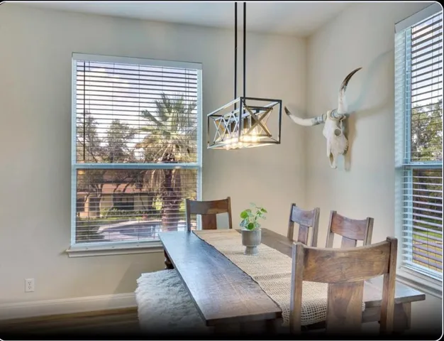 a view of a dining room with furniture large windows and wooden floor