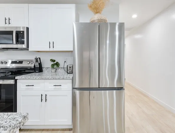 a kitchen with stainless steel appliances granite countertop a refrigerator sink and microwave