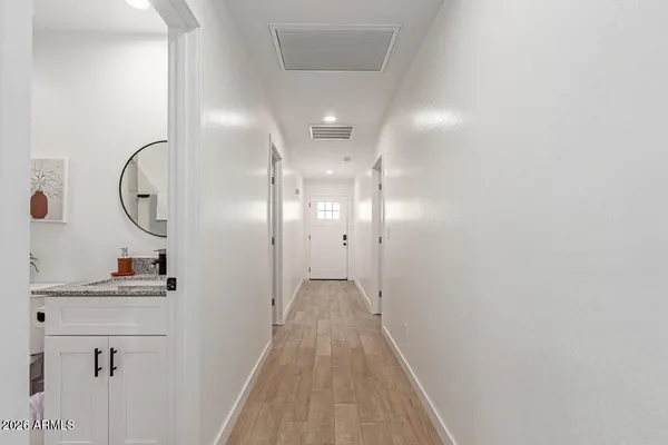 a view of a hallway with wooden floor