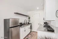 a kitchen with stainless steel appliances granite countertop a sink a stove and a refrigerator