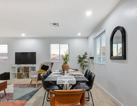 a living room with furniture a flat screen tv and a potted plant