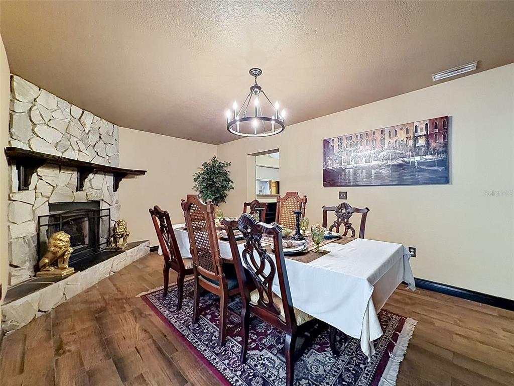 7111 Ricker Avenue Webster, FL 33597 - Photo 18 of 41 a view of a dining room with furniture wooden floor and a chandelier