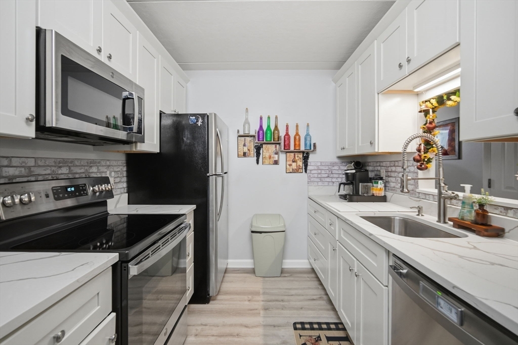 32 Maple Crest Circle, Unit G Holyoke, MA 01040 - Photo 13 of 34 a kitchen with a sink stove and refrigerator
