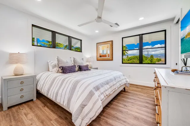 a bedroom with a large bed and a flat tv screen on dresser