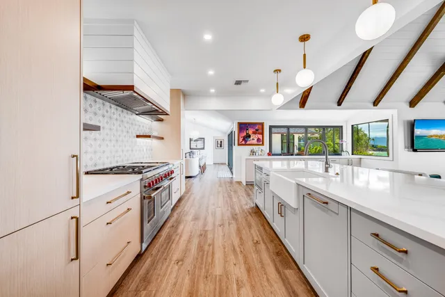 a large kitchen with stainless steel appliances granite countertop a lot of counter space and wooden floors