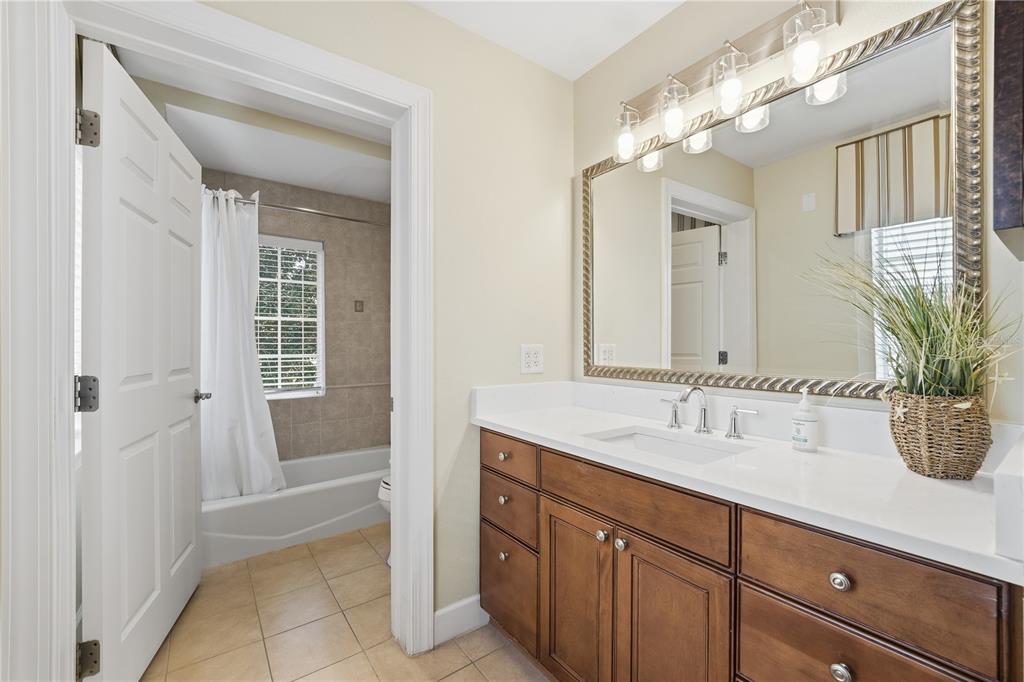 1354 Centre Ct Ridge Drive, Unit 204 Reunion, FL 34747 - Photo 27 of 46 a spacious bathroom with a granite countertop sink a mirror and a shower